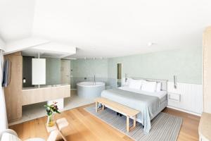 a bedroom with a large bed and a bath tub at Hotel Bommeljé in Domburg