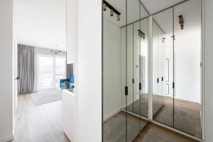 a bathroom with glass showers in a white room at City Center Apartamentai Šatrijos g in Vilnius +28 photos