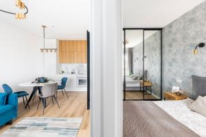 a bedroom and living room with a bed and a dining room at City Center Apartamentai Šatrijos g in Vilnius