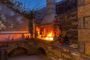 a kitchen with a brick oven with a fire in it at Villa Lela Seaview by Villa Plus in Chavgas