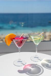 two martini glasses sitting on a table with an orange slice at Flamboyan Caribe Hotel & Spa in Magaluf