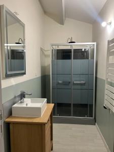 ロワイヤにあるMaison 4 personnes au centre de Royatの洗面台とガラスのシャワーを備えたバスルーム