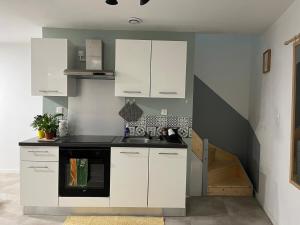 ロワイヤにあるMaison 4 personnes au centre de Royatのキッチン(白いキャビネット、黒いコンロ付) +11枚の写真