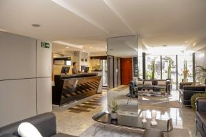 a man is sitting at a desk in a lobby at Slaviero Hotel Curitiba Batel in Curitiba