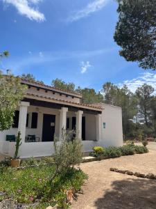 a small white building with trees in the background at Tranquila casa unica en Playa Mitjorn Formentera in Playa Migjorn