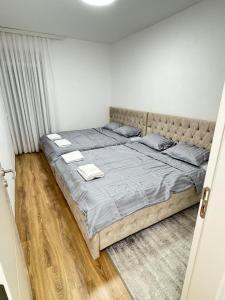 a bedroom with a large bed with two towels on it at ANI apartment 1 in Ulcinj