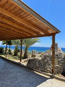 a wooden pavilion with the ocean in the background at Villa Rose in Archangelos
