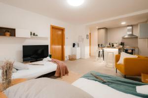 a living room with a bed and a kitchen at Casa Augusta Renovada Centro Histórico 5 Pax in Zaragoza