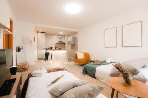 a living room with two beds and a table at Casa Augusta Renovada Centro Histórico 5 Pax in Zaragoza