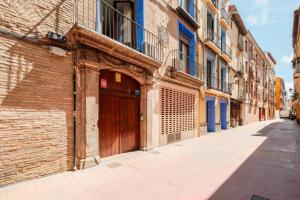 a brick building with a wooden door on a street at Casa Augusta Renovada Centro Histórico 5 Pax in Zaragoza