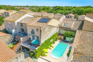 an aerial view of a house with a swimming pool at Villa de la Cloche by Villa Plus in Pouzolles