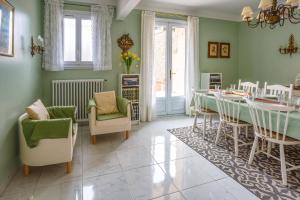 a dining room with green walls and a table and chairs at Villa de la Cloche by Villa Plus in Pouzolles