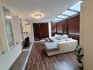 a living room with a white couch and a tv at Villa Alva in Pomorie