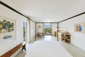 a bedroom with a large bed and a table at Casa Via Costa in Ischia