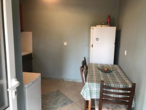 a small kitchen with a table and a refrigerator at Epicurus beach cottage in Kánalos