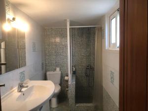 a bathroom with a sink and a shower with a toilet at Epicurus beach cottage in Kánalos