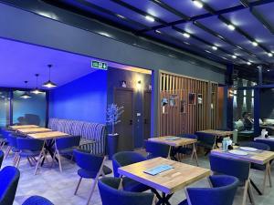 a restaurant with wooden tables and blue chairs at Paddys Apartments, Hisarönü in Fethiye