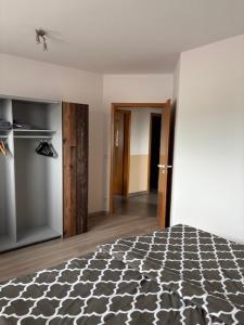 a bedroom with a black and white bed and a kitchen at 3 Zimmer Ferienwohnung Nummer 1 in Hilter am Teutoburger Wald