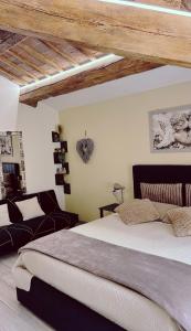a bedroom with a large bed and a couch at Appartamento "IL PORTICO" a pochi minuti da IMOLA e FAENZA in Imola