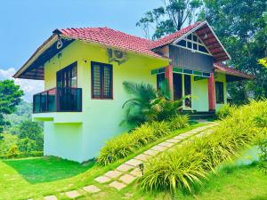 a yellow house with a red roof at Vaca Vibes Resorts in Koroth