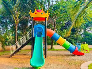 a playground with a colorful slide with a crown on it at Vaca Vibes Resorts in Koroth