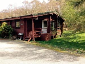 a log cabin with a grill in front of it at Crowlin Lodge in Duirinish