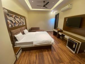 ein Schlafzimmer mit einem Bett und einem Flachbildfernseher in der Unterkunft Pink Mahal Hotel & Resort in Jaipur + 22 Fotos