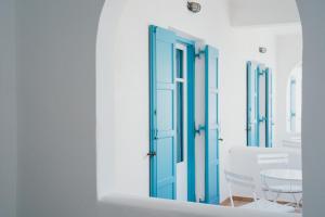 Zimmer mit blauer Tür und einem Tisch in der Unterkunft Paros Inn Seafront in Logaras