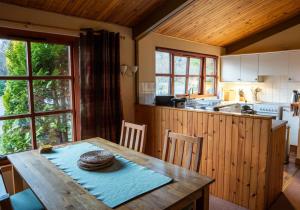 a kitchen with a wooden table with a straw hat on it at Rhum Lodge in Duirinish