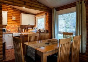 a kitchen and dining room with a table and chairs at Longay Lodge in Duirinish