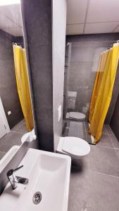 a bathroom with a white sink and a toilet at Kjara Apartment-Airport in Petrovec +16 photos