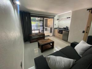 un soggiorno con un divano e un tavolo di The Hideaway a Nelspruit Altre 8 foto