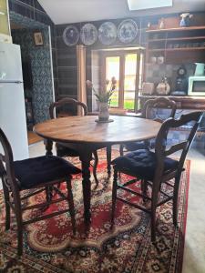 a kitchen with a wooden table and two chairs at Les Chanterelles La souris des champs in Étival-Clairefontaine