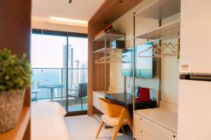 Zimmer mit einem Schreibtisch und einem Balkon in der Unterkunft Studio 25 andar a 350m da Beira Mar com Rooftop in Fortaleza