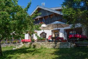 a house with chairs and umbrellas in front of it at Ferme-Auberge du Rondeau in Lavans-Vuillafans