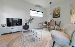 a living room with a couch and a tv and a table at 2 Bedroom Amazing Home In Hellendoorn in Hellendoorn