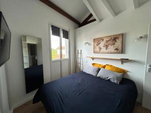 a bedroom with a blue bed and a window at La Chouette du lac Marion in Biarritz
