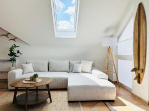 a white living room with a couch and a table at HAFENROMANTIK - Wohnen mit Charme im Herzen von Neustadt mit Blick auf das Binnenwasser in Neustadt in Holstein