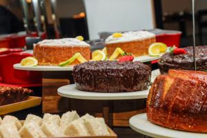 a display of different types of cakes and pastries at Slaviero Hotel Curitiba Batel in Curitiba