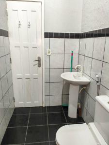 Un baño blanco con lavabo e inodoro. en Residencial Alves, en Paragominas