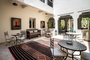 a living room with tables and chairs and a rug at Riad Malaika in Marrakech