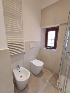 une salle de bain blanche avec toilettes et lavabo dans l'établissement Terrazza nel centro storico, à Rapallo 5 autres photos
