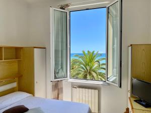 Un dormitorio con un gran ventanal con vista al mar. en Hotel Gambone, en Finale Ligure
