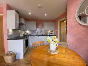 a kitchen with a wooden table with flowers on it at Grouse Cottage in Kilninian