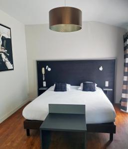 a bedroom with a large bed with a black headboard at Auberge Du Cheval Blanc in Baud
