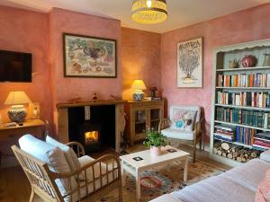 a living room with a couch and a fire place at Grouse Cottage in Kilninian