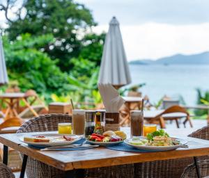 a wooden table with plates of food on it at Ten Moons Sunset Villas in Ko Lipe