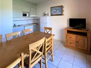 une cuisine et une salle à manger avec une table et des chaises en bois dans l'établissement Chalet 3 pièces à La Joue du Loup avec parking, 7 personnes - FR-1-504-45, à Saint-Étienne-en-Dévoluy