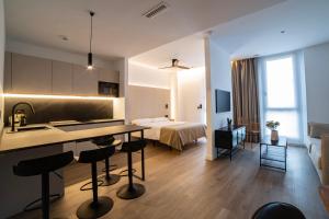a hotel room with a kitchen and a bedroom at Demetrio By Alma Suites in Valencia
