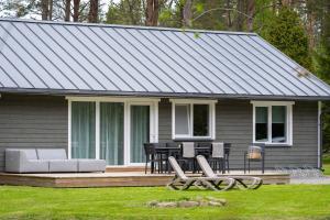 PaopeJõeranna Lodge的房屋设有门廊,配有桌椅